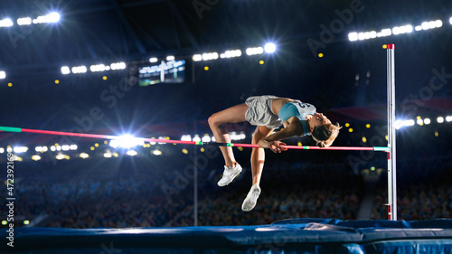 High Jump Championship: Professional Female Athlete on World Championship Successfully Jumping over Bar. Shot of Competition on Stadium with Sports Achievement Experience. Determination of Champion.