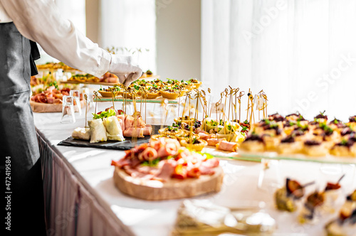 waiter prepare food for a buffet table in a restaurant