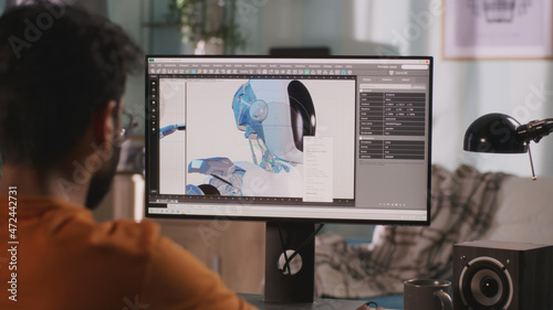 Unrecognizable guy creating and rendering 3D model of futuristic robot for film while working on remote project at home