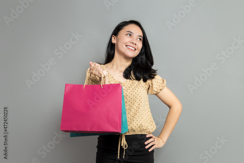 Beautiful woman looking up while holding shopping bags