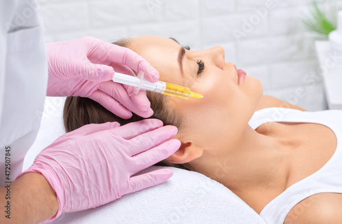 Cosmetologist does prp therapy of a beautiful woman in a beauty salon. Cosmetology concept.