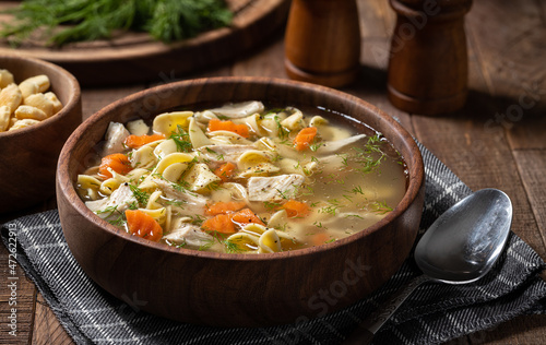 Bowl of chicken noodle soup on a wooden table