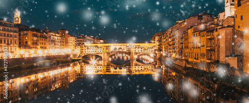 snowfall over Florence Ponte Vecchio on river Arno at night, winter in Italy