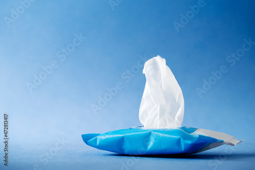 Open wet wipes flow pack on blue background. High quality photo