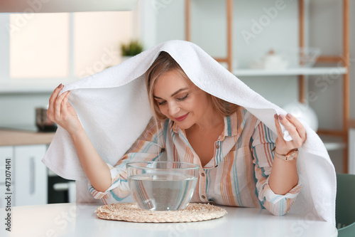 Woman doing steam inhalation at home to soothe and open nasal passages