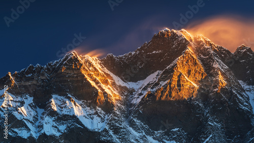 first sun lights on the peaks of Lhotse and Nutse under blue sky in Nepal