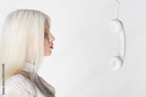 Side view of telephone handset near albino woman isolated on white.