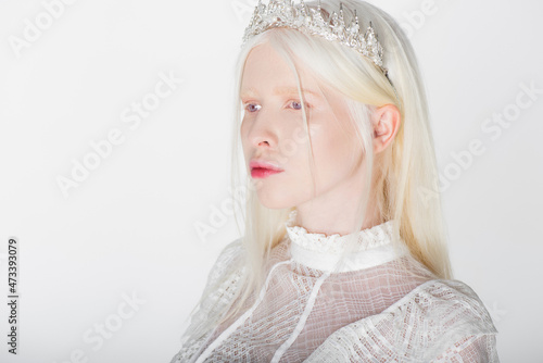 Pretty albino woman in crown with pearls and gems isolated on white.