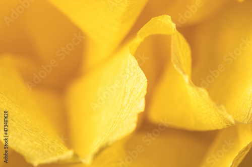 Fragment of a yellow flower made of crepe paper. Macro photography