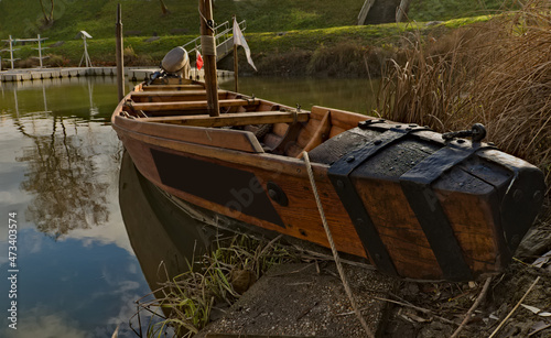 At the marina . Drewniana łódź ( barkas , czółno ) zacumowana przy nabrzeżu . Wooden boat (Canoe) moored by the waterfront .