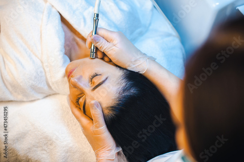 Woman's face receiving a microdermabrasion treatment in beauty salon. Rejuvenation treatment. Facial treatment. Beauty skin female face.