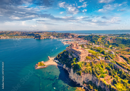 Aerial landscape photography. Beautiful view from flying drone of Aragonese Castle of Baia, Italy, Europe. Wonderful morning seascape of Mediterranean sea. Traveling concept background.