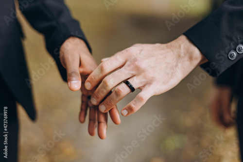 European Gay Couple holding hands, homosexual marriage wedding day. Gentle touch of a same sex couple