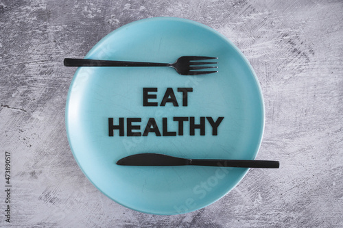 eat healthy text on dining plate with fork and knife, dieting vs healthy nutrition and intuitive eating