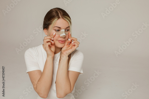 A young woman with a bandage on her nose after rhinoplasty