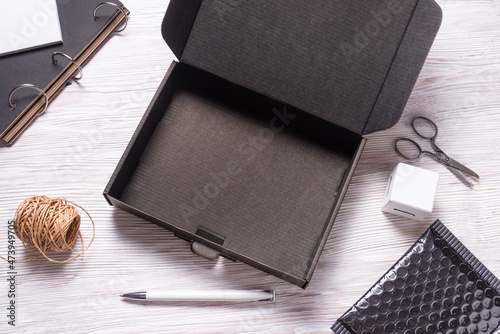 Black cardboard box on wooden office desk