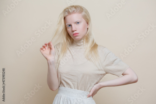 Cute albino girl on a beige background.
