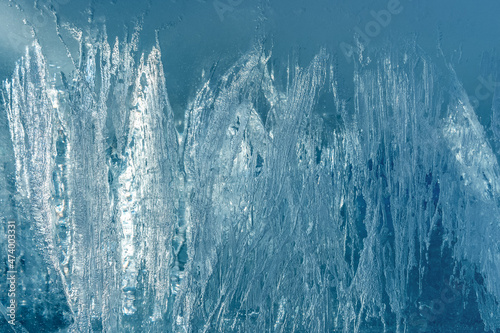 The texture and pattern of transparent ice with crystals. Abstract blue ice background.