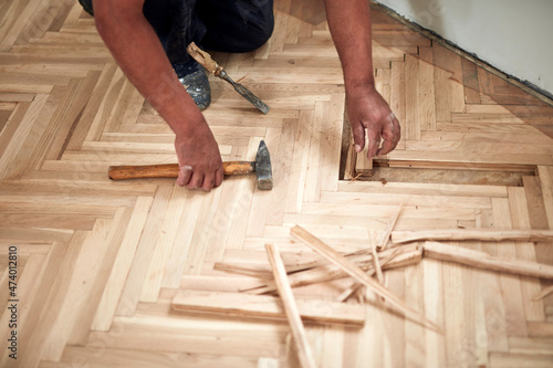 Repairman restoring old parquet hardwood floor.