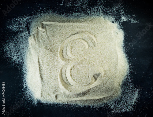 Greek letter epsilon written on the white sand with black background