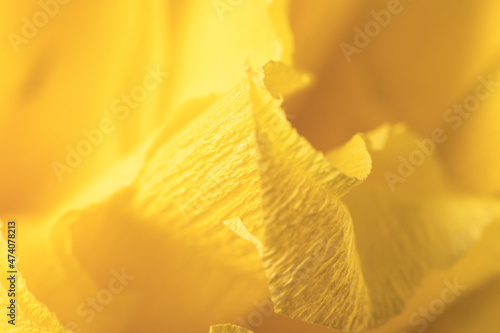 Fragment of a yellow flower made of crepe paper. Macro photography