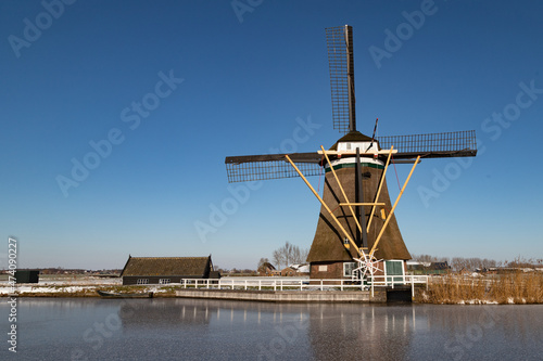 Windmill in the wintry polder landscape in the Netherlands.