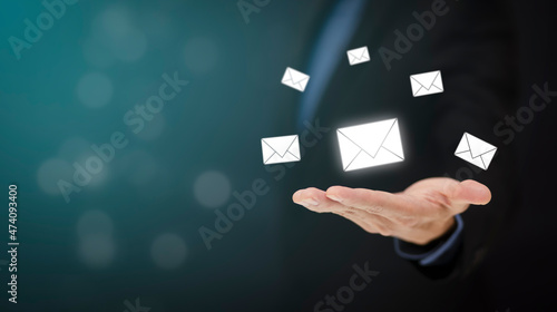 Businessman hand holding e-mail icon letter on a touch screen interface, virtual postal envelope, concept of spam email, internet and networking, Contact us newsletter email and protect your personal.