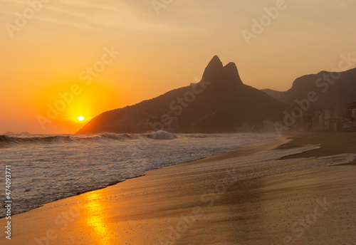 Ipanema Beach, Brazil on a Sunset at summer. Two Brothers Mountain on background with beautiful waves from the ocean