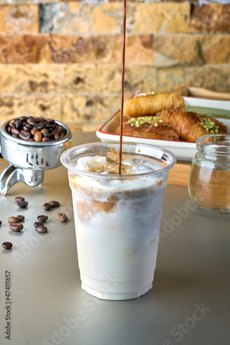 Iced Latte coffee with sweets with coffee beans on dark background