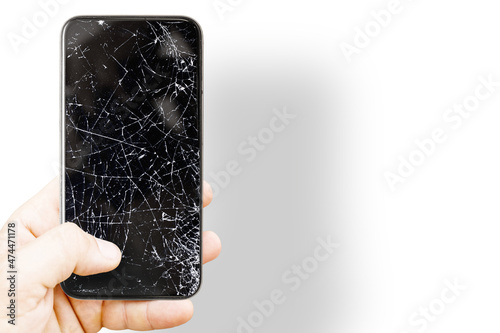 Black mobile phone with broken screen. Cracked smartphone in hand