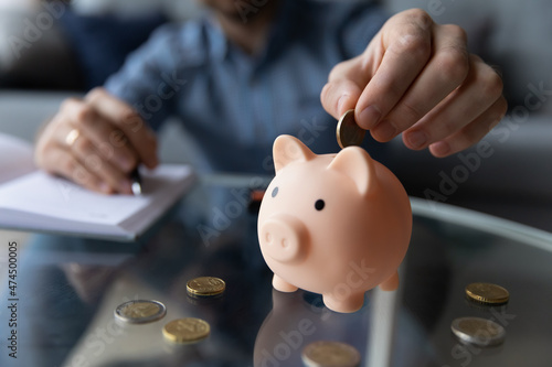 Personal savings, planning budget and money for future, frugal person concept. Close up male hand putting eur coins into piggy bank. Thrifty man add cash in moneybox thinks about tomorrow, makes stash