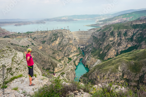 Hiker on a cliff overlooking the Chirkey dam and the Sulak canyon in Dagestan