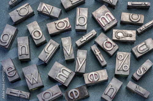 background of random vintage grunge letterpress metal type printing blocks against textured paper