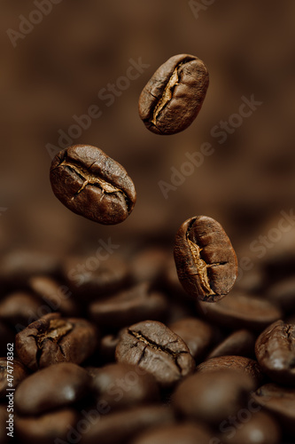 Macro Photo of Coffee Beans Falling on a Pile of Beans on Dark Background Vertical