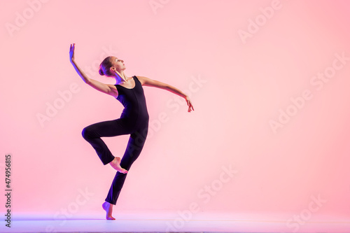 Young teenager dancer dancing on a red studio background. Ballet, dance, art, modernity, choreography concept