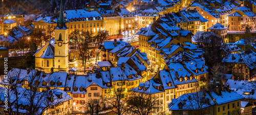 Alleys and lanes of the town center of Bern in winter blue hour with snow-covered roofs and illuminated buildings in Christmas season, Rosengarten, Bern, UNESCO, Switzerland