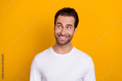 Portrait of satisfied candid person toothy smile look interested empty space isolated on yellow color background