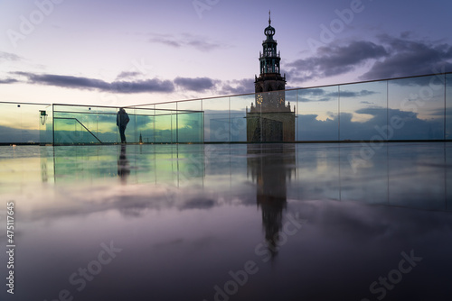 A man on the roof of the Forum building, enjoying the view at Groningen during dusk.