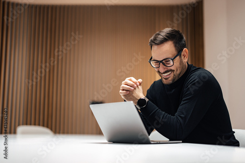 Joyful adult man, attending a meeting online on his macbook.