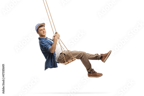 Side shot of a casual guy swinging on a wooden swing