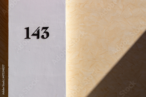 Closeup of the number 143 on a stone wall