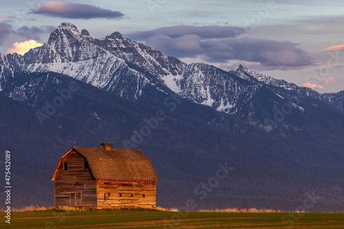 Rustic old barn in evening light with Mission Mountains in Pablo, Montana, USA