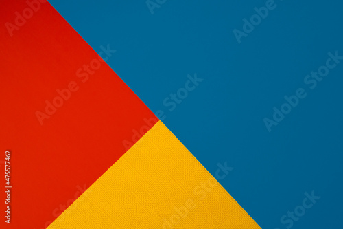 Bright abstract geometric paper background. Red, blue and orange yellow trendy colors. The backdrop for an invitation card, greeting card or web design. Creative copy space, flat lay