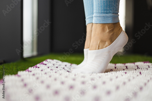 Female feet standing on acupressure mat. Alternative medicine concept
