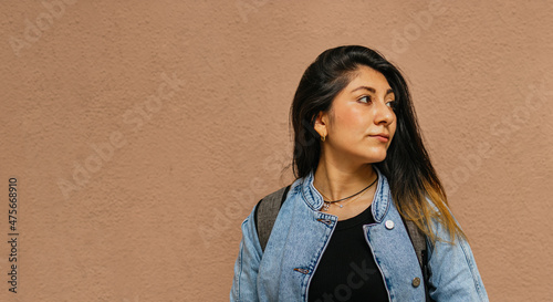 A latina lady looking to the left on unicolor background