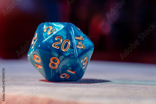 Close-up image of a blue role-playing gaming die with 20 sides