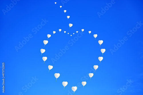 Białe balony w kształcie serc, dużego serca, szybujące na tle niebieskiego nieba, wesele, uczucia i emocie, zasoby graficzne.