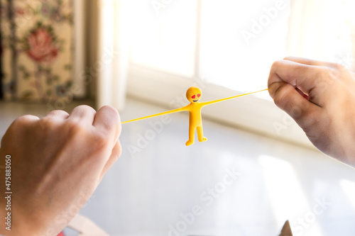 Hands of a kid playing with an elastic and funny toy at home.