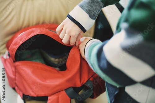 Dziecko pakujące plecak przed wyjściem do szkoły
