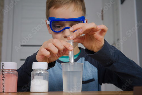 młody chłopak uczy się, przeprowadza eksperyment naukowy 